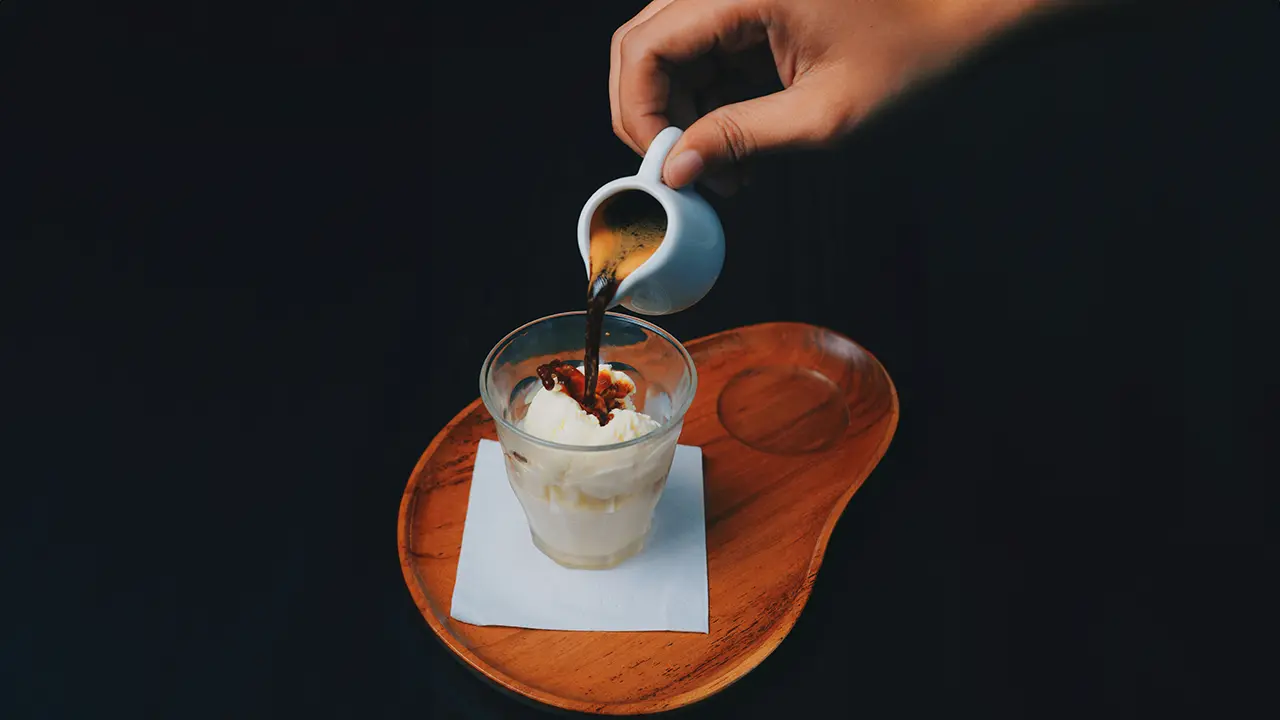 Espresso wird in Glas mit Vanilleeis gegossen