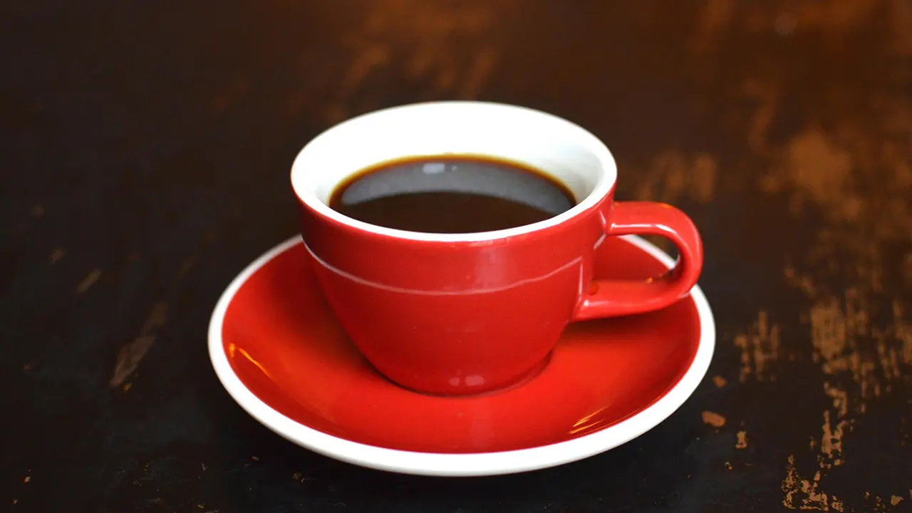 Ein rote Tasse mit einem Americano