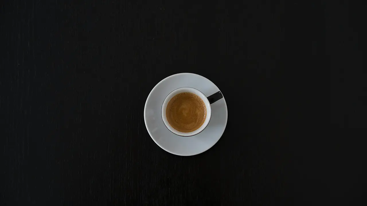 Eine Tasse Espresso von oben gesehen auf einem dunklem Untergrund