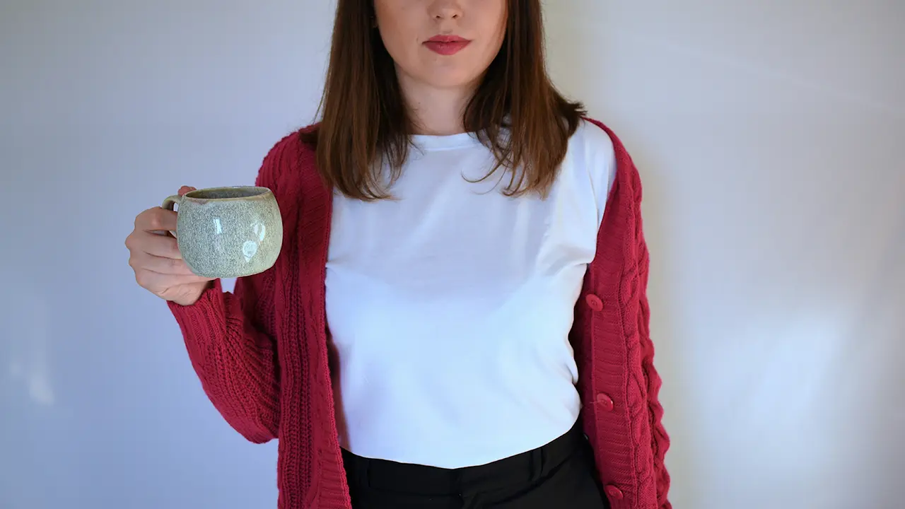 Ein junge Frau hält eine Kaffeetasse
