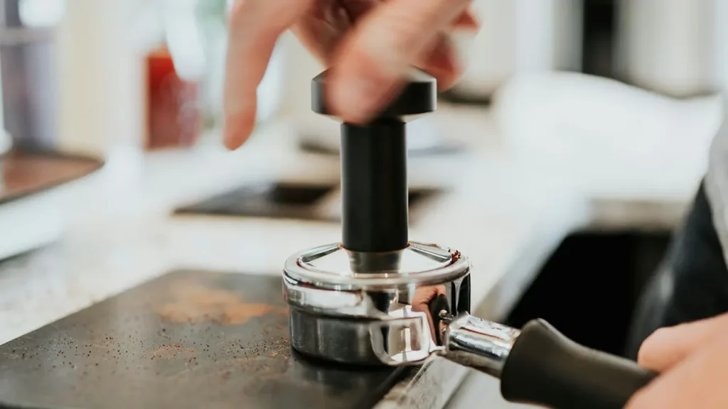 Ein Barista tampt einen Espresso
